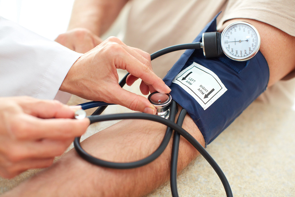 Picture of clinician measuring patient blood pressure.